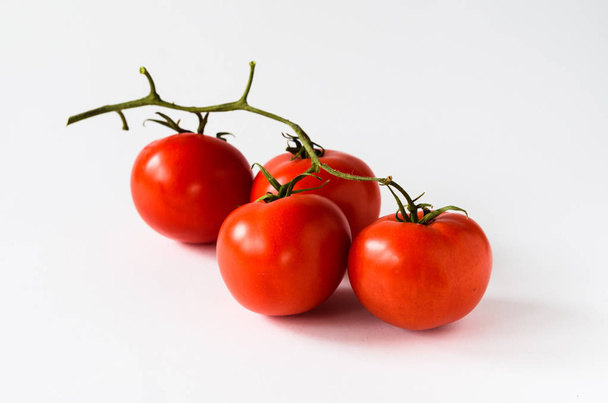 Zweig mit vier Tomaten auf weißem Hintergrund - Foto, Bild