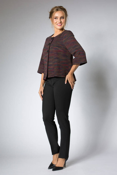 Beautifle woman posing in colored blouse and black pants - Foto, Imagen