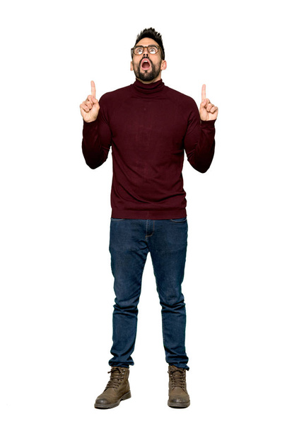 Full-length shot of Handsome man with glasses surprised and pointing up on isolated white background - Фото, зображення