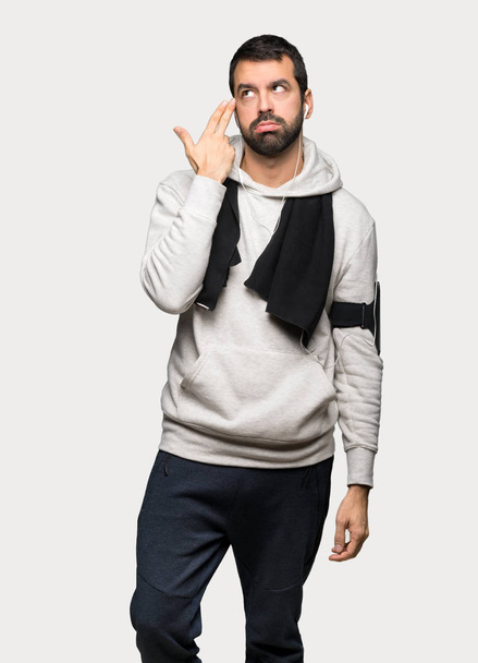 Sport man with problems making suicide gesture over isolated grey background - Photo, Image