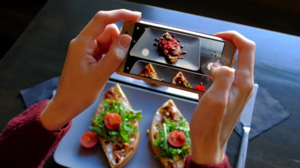 Womans ręce przy użyciu smartfona wziąć zdjęcie z żywności przed jedzenie w restauracji - Materiał filmowy, wideo