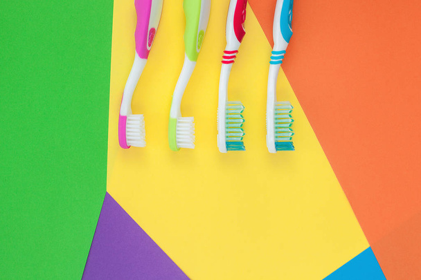 Zahnbürsten auf buntem, hellem Hintergrund. Familienhygienekonzept.  - Foto, Bild
