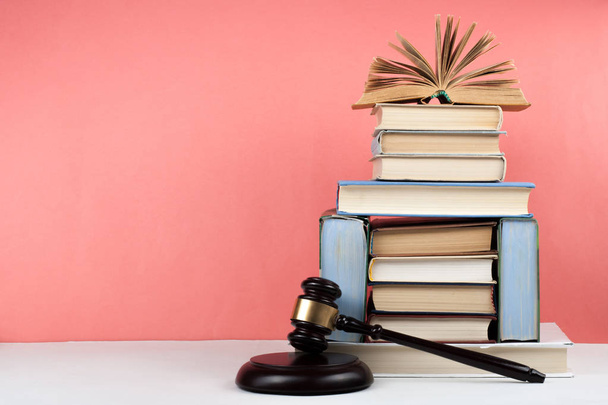 Hardback colorful books stacking with gavel on wooden table and pink background. Law Education business concept - Photo, image