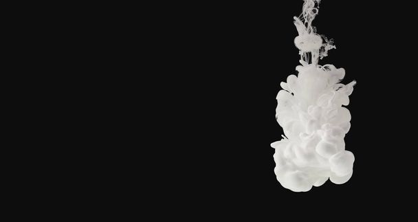 White paint flowing in water isolated on black - Foto, Bild