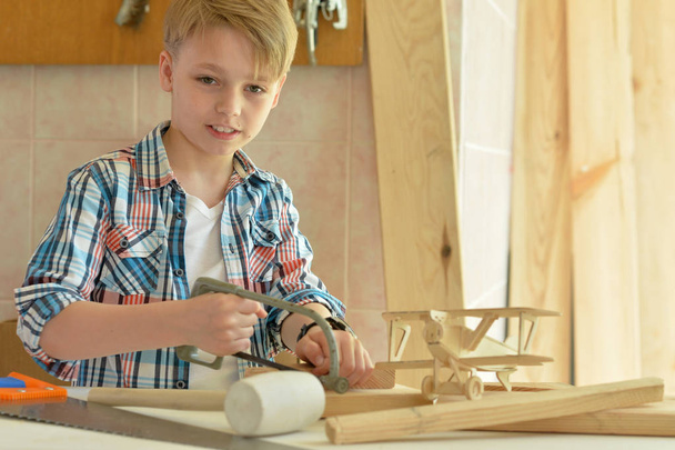cute little boy  working with wood in  workshop - 写真・画像