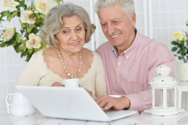 happy Senior couple portrait drinking tea  and using laptop - Photo, image