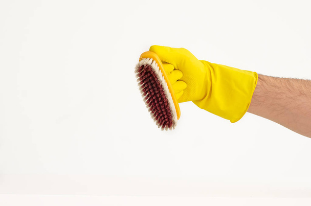 Brazo masculino en guante de látex amarillo con cepillo de lavado de color
 - Foto, Imagen