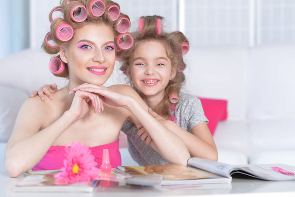 portrait of happy  Mother and little daughter with hair curlers at home - Foto, immagini