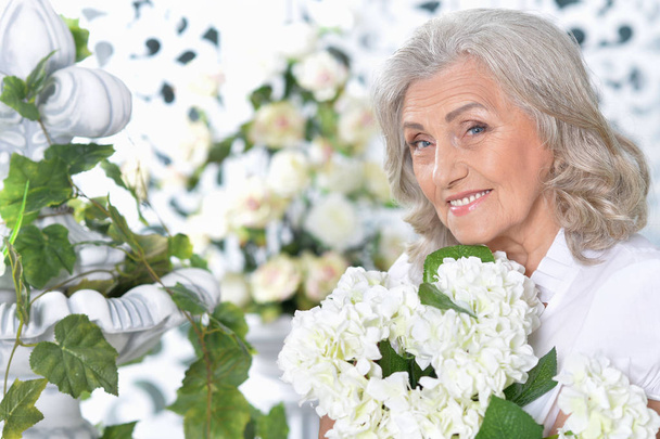 Portrait of happy senior woman posing with flowers  - Foto, Imagem