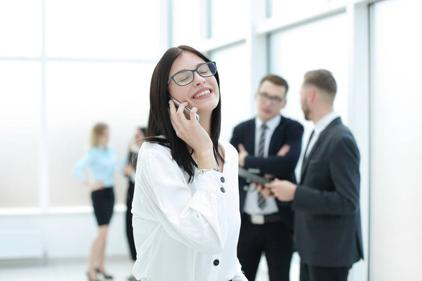 happy business woman talking on smartphone in office lobby - Фото, изображение