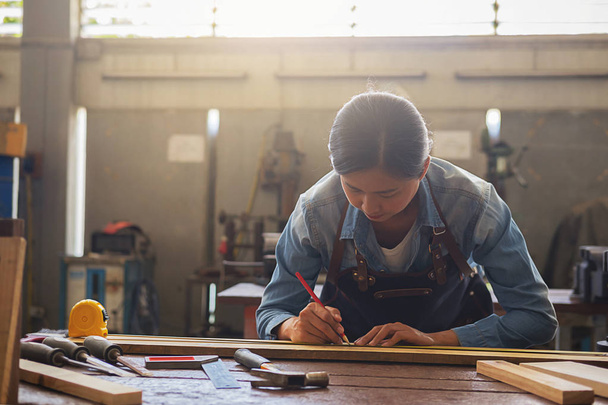 Falegname che lavora su macchine per la lavorazione del legno in falegnameria. donna lavora in una falegnameria
. - Foto, immagini