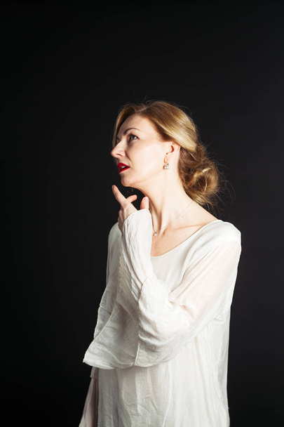 Close up studio portrait of beautiful woman in a white dress against black background - Fotografie, Obrázek
