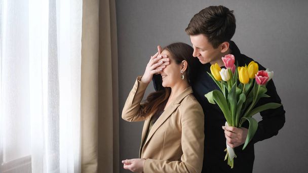 Surprised woman receive tulip flowers from her boyfriend - Photo, Image
