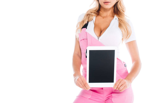 oříznutý pohled šikovná žena v růžové uniformě drží digitální tabletu s prázdnou obrazovkou izolované na bílém - Fotografie, Obrázek