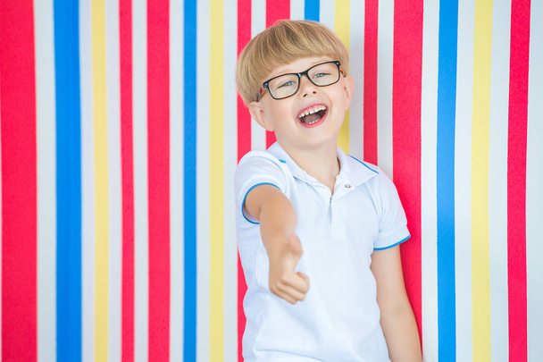 Χαριτωμένο παιδί κοντινό πορτραίτο σε πολύχρωμο φόντο. Αξιολάτρευτο μικρό αγόρι, που στέκεται κοντά στον τοίχο. - Φωτογραφία, εικόνα