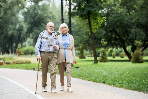 happy stylish senior couple enjoying walking in park - Photo, Image