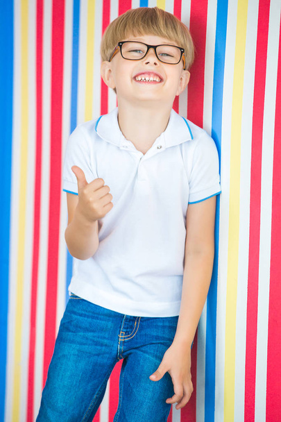Enfant mignon portrait rapproché sur fond coloré. Adorable petit garçon debout près du mur
. - Photo, image