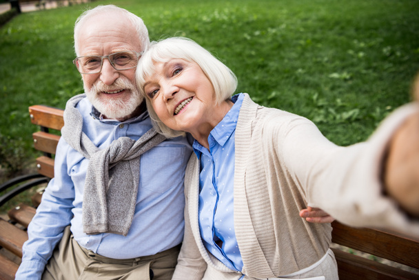 foyer sélectif de heureux couple de personnes âgées assis sur un banc en bois dans le parc
 - Photo, image