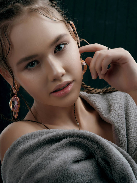 jonge model met gevlochten haar poseren in studio - Foto, afbeelding