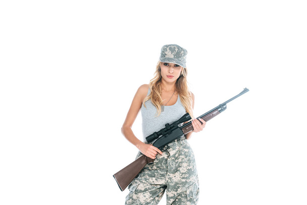 militarywoman v šedé triko, maskovací kalhoty a čepici držel zbraň izolované na bílém - Fotografie, Obrázek