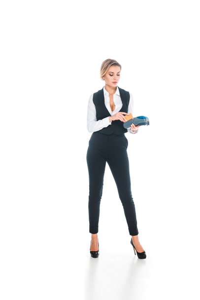 loira atraente garçonete em uniforme preto fazendo transação com cartão de crédito e terminal isolado no branco
 - Foto, Imagem