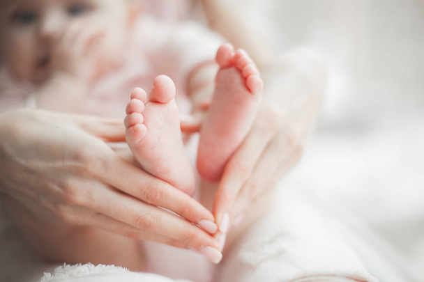 Vauvan jalat lähikuva kuva. Äidin kädet pitelevät lapsen jalkaa. Pikkutytön sormet edessä. Vanhemmuuden taustaa
. - Valokuva, kuva