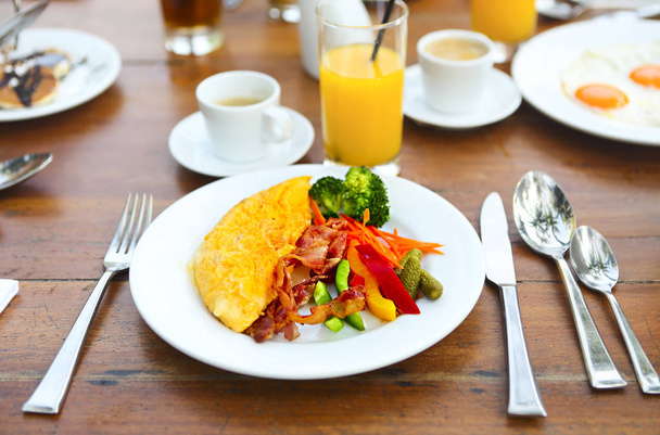 Omelett mit Paprika, Gurke, Bakon und Salat auf dem Tisch im Freien - Foto, Bild