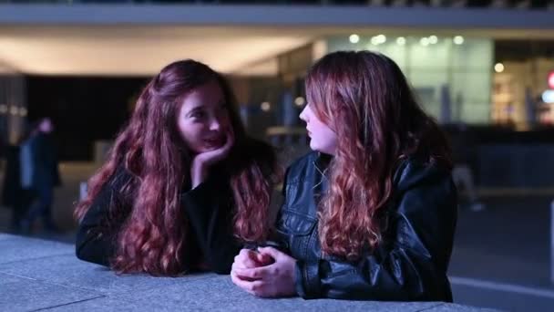 Αργή κίνηση δύο νεαρών γυναικών σε εξωτερικούς χώρους τη νύχτα κουβεντιάζοντας φιλία, ομαδικότητα, έννοια συγκόλλησης - Πλάνα, βίντεο