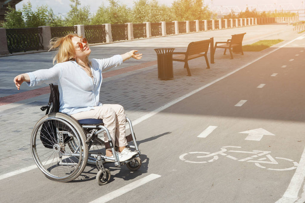 γυναίκα στο αναπηρικό αμαξίδιο ιππασία ποδήλατο δρόμου στο πάρκο της πόλης το καλοκαίρι - Φωτογραφία, εικόνα