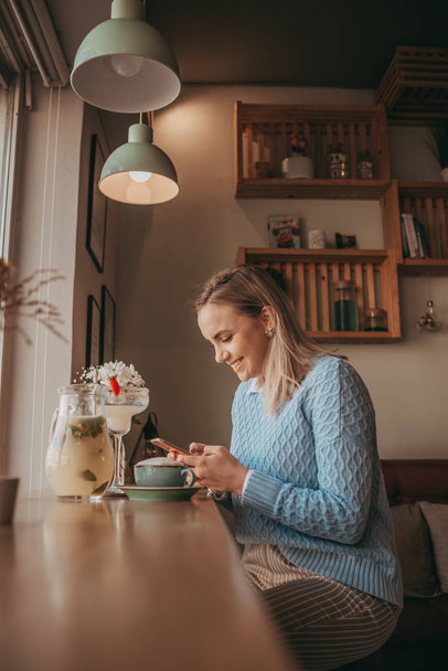 Молодой гриль ест блинчики и пьет белый кофе
 - Фото, изображение
