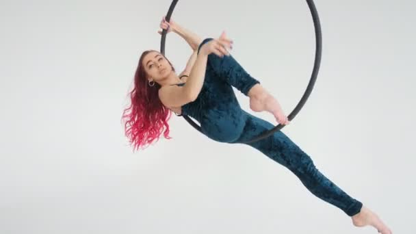 Concept of dance and gymnastics. Young beautiful woman on aerial hoop on a white background - Footage, Video
