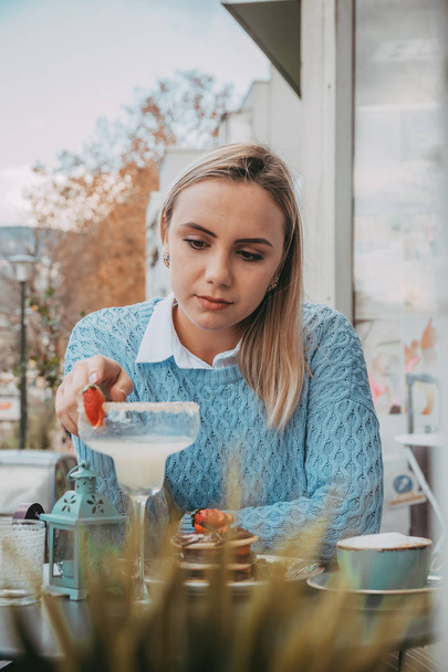 Молода решітка їсть млинці та п'є білу каву
 - Фото, зображення