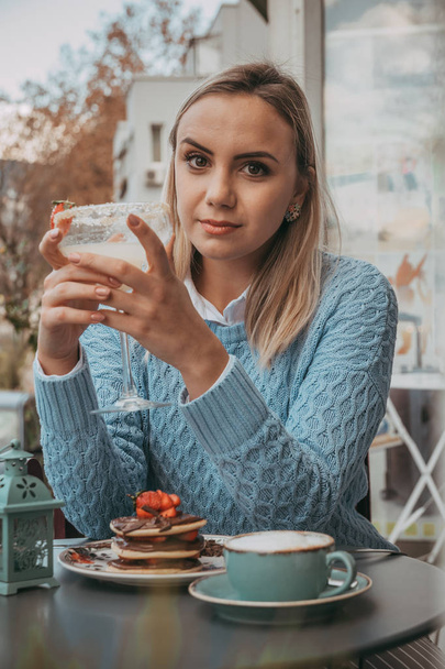 Jeune gril manger des crêpes et boire du café blanc
 - Photo, image