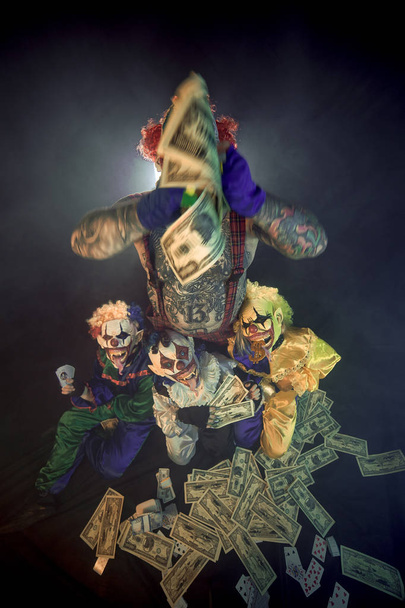 scary clowns having fun and throwing cash - Foto, afbeelding