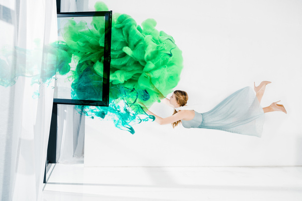  schwebendes Mädchen, das grüne und türkisfarbene Wolken berührt Illustration  - Foto, Bild