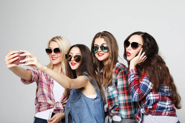  four happy teenage girls with smartphone taking selfie - 写真・画像
