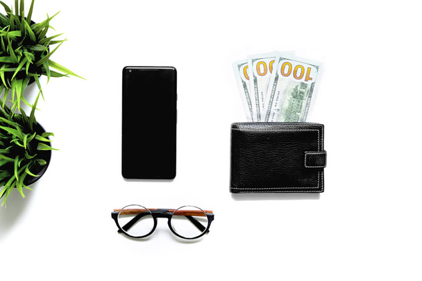 Flatlay of money in black wallet, mobile phone, glasses on white background. Top view. business payments concept. - Fotoğraf, Görsel