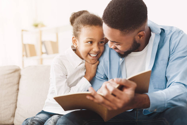Papa afro-américain et sa fille passent du temps, lire le livre
 - Photo, image