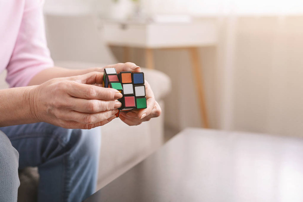 Vieille femme tenant Rubiks cube et jouer avec elle
 - Photo, image