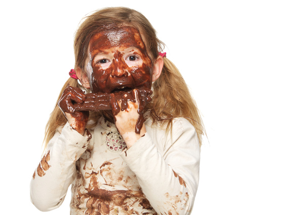 Portrait d'une petite fille mangeant des barres de chocolat et le visage recouvert de chocolat
 - Photo, image
