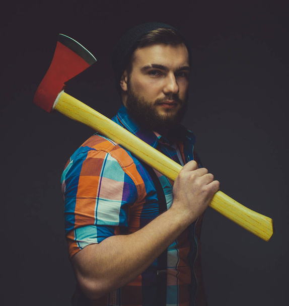 Bearded man with axe posing over black background in studio - Foto, imagen