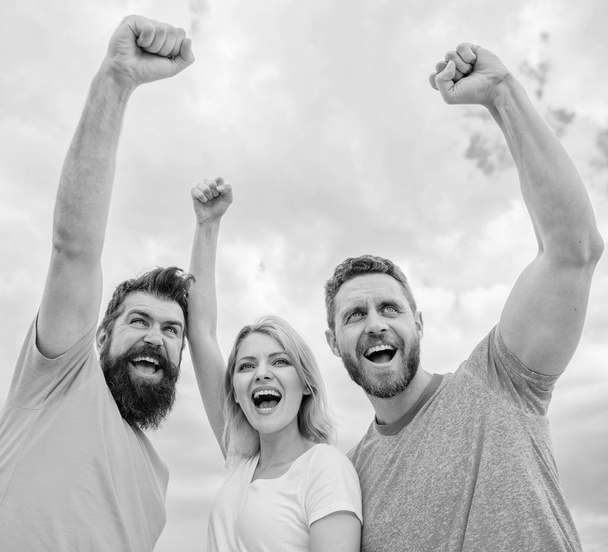 Woman and men look confident successful sky background. Behaviors of cohesive team. Celebrate success. Yes we can. Ways to build ohesive team. Threesome stand happy confidently with raised fists - Foto, Bild