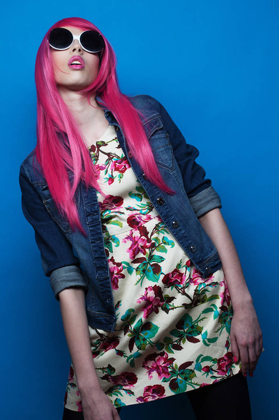 fashion model with pink hair and big sunglasses over blue  background - Fotografie, Obrázek