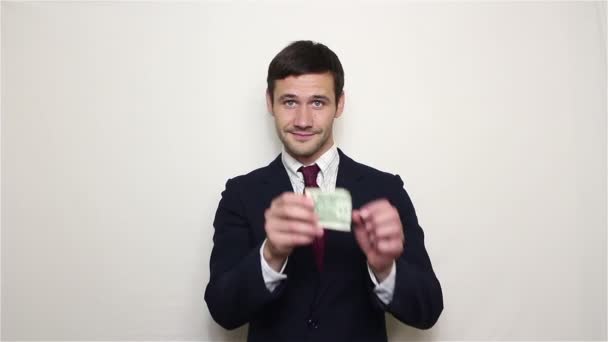 Young handsome businessman pulls one dollar out of his pocket and shows it. - Video, Çekim