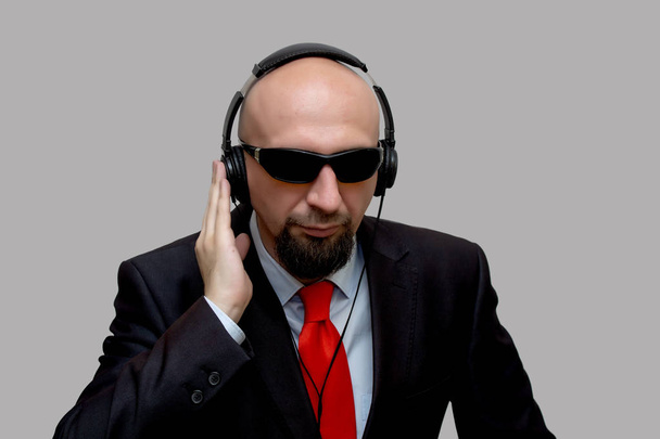 Agente secreto del FBI escucha y graba la conversación.Un hombre calvo con auriculares, escuchando la conversación secreta, el explorador - Foto, imagen