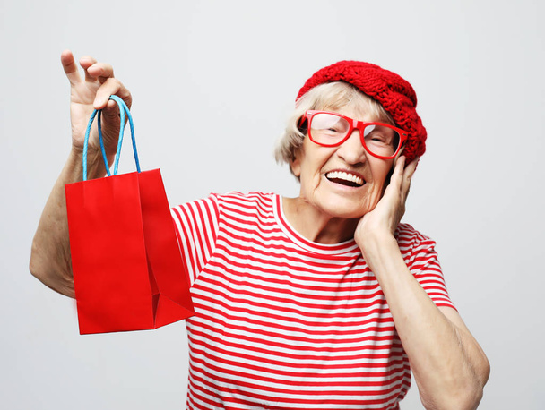 lifestyle, holiday and people concept: elderly woman with gift bag. - 写真・画像
