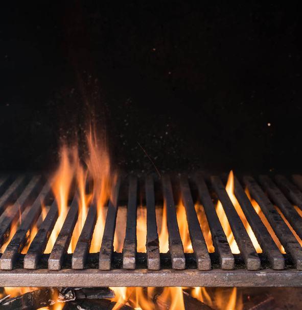 Empty grill grate and tongues of fire flame. Barbeque night background. - Photo, image