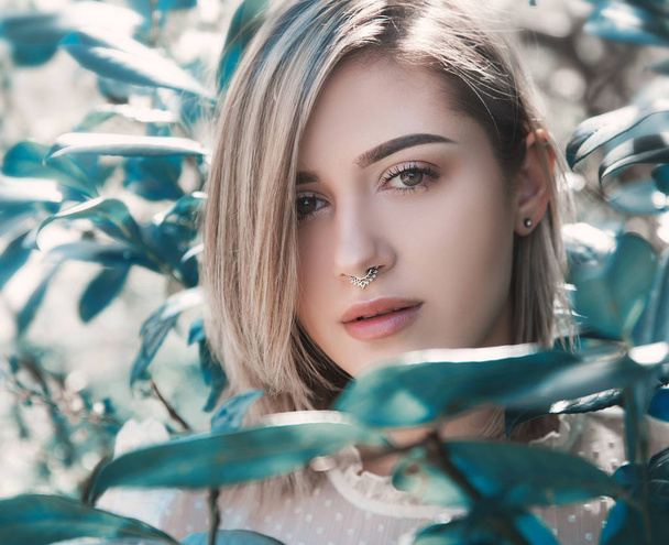 Portrait of young woman posing in tree foliage - Foto, Imagem
