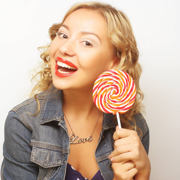 beautiful young woman with big colorful lollipop - Фото, зображення