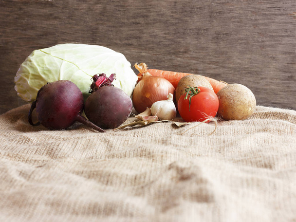 Raw vegetables for beet soup borsch. White cabbage, beet, carrot, potato, tomato, garlic on wooden board - Photo, Image